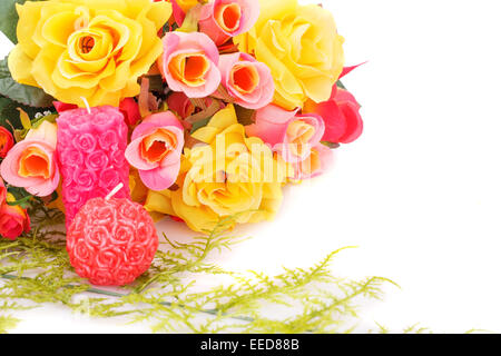 Bunte Rosen und Kerzen auf weißem Hintergrund. Stockfoto