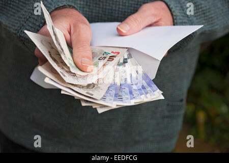 Nahaufnahme einer Person mit englischen Geldscheinen Banknoten Bargeld und weißem Umschlag Finanzen Business Concept England Großbritannien Großbritannien Stockfoto