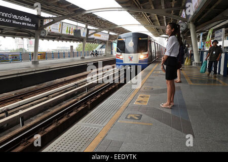 Junge Asiatin wartet an der Sathorn Station, öffentlichen Nahverkehr Skytrain Zug, Bangkok, Thailand, Südostasien. Stockfoto