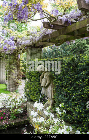 Keukenhof Gärten im Frühjahr.  Statue unter Blauregen-pergola Stockfoto