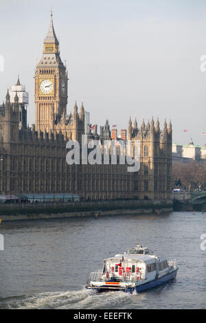 Ein Thames Clipper-Dienst übergibt die Houses of Parliament an einem Winternachmittag Stockfoto