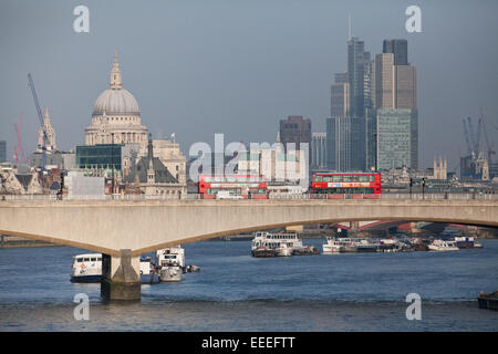 Zwei Doppeldeckerbusse fahren über die Themse mit Blick auf die Stadt und St. Pauls Stockfoto