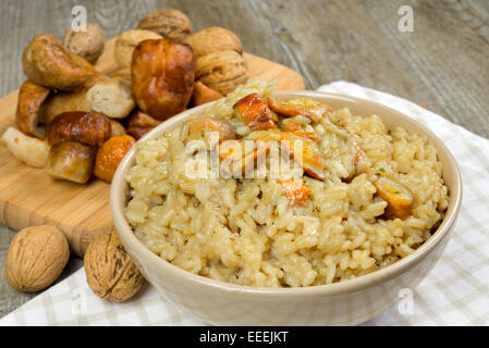 Risotto mit Steinpilzen auf Holztisch Stockfoto