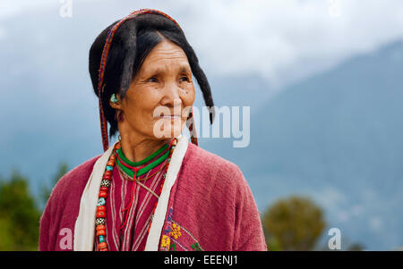 Eine Frau des Stammes Monpa gekleidet in traditioneller Kleidung und Perlenkette und auch ein Yak-Haar-Hut. Stockfoto