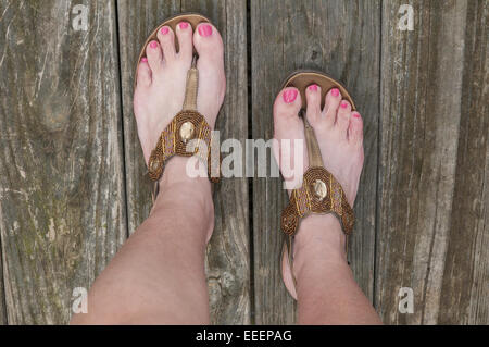 Womans Füße in offenen toed Perlen, Gold Sandalen Stockfoto