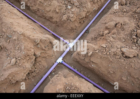 Rohr für unterirdische Bewässerungssystem in offenen Schmutz Gräben während des Baus der eine Garten-Bewässerungs-System. Stockfoto