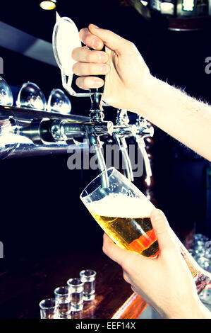 Barkeeper geben das Bier aus Spender. Alkohol-Konzeptbild. Stockfoto