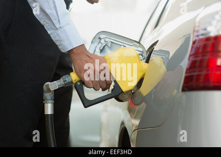 Pumpen von Gas. Nahaufnahme des Mannes Pumpen Benzin Kraftstoff im Auto an Tankstelle. Stockfoto