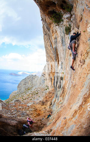 Junger Mann Blei Klettern auf Felsen in der Nähe von Meer, Insel Kalymnos, Griechenland Stockfoto
