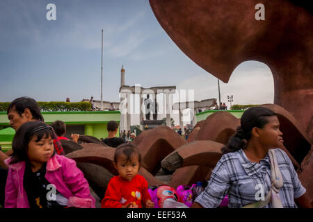 Menschen, die sich in der Nähe des Heroes Monument (10. November Monument) und der Soekarno-Hatta Statue in Surabaya, Ost-Java, Indonesien, Freizeit nehmen. Stockfoto