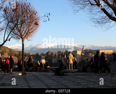 Touristen auf Albaicín Hügel bewundern, die Alhambra-Palast & Festung in Granada, Spanien, mit den Bergen der Sierra Nevada im Hintergrund Stockfoto