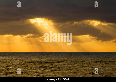 Die Sonne durch die Wolken auf See rund um die Kanarischen Inseln. Stockfoto