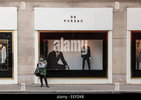 ein Tourist, Blick auf eine Karte außerhalb De Fursac Männer Anzug Shop, Pars, Frankreich Stockfoto