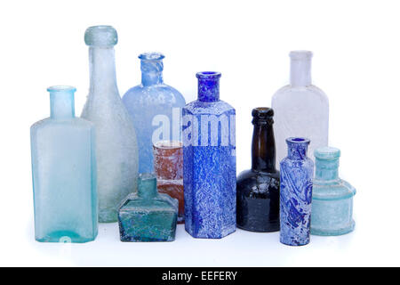 Alte antike Glasflaschen in verschiedenen Farben auf weißem Hintergrund. Stockfoto