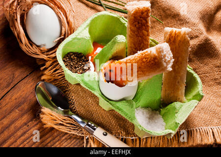 Freilandeier und geröstetem Brot Soldaten in ein grünes Ei-Behälter serviert. Stockfoto