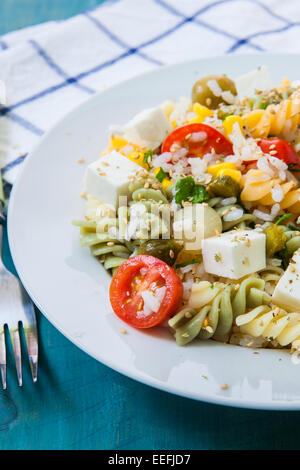 Nudelsalat mit Tomaten-Reis und Feta-Käse auf weißen Teller Stockfoto