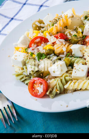 Nudelsalat mit Tomaten-Reis und Feta-Käse auf weißen Teller Stockfoto