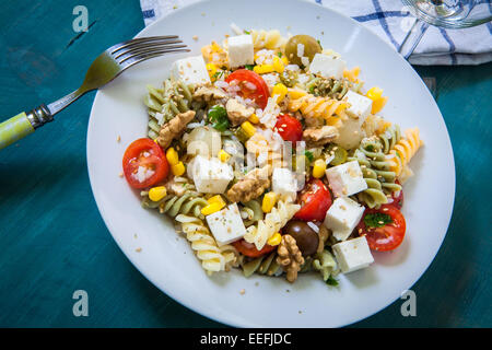 Nudelsalat mit Tomaten-Reis und Feta-Käse auf weißen Teller Stockfoto