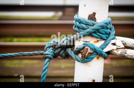 Ein Seil gebunden in einem Knoten um eine Barriere auf Hythe Pier, Leute aus den Straßenbahnschienen zu halten. Stockfoto