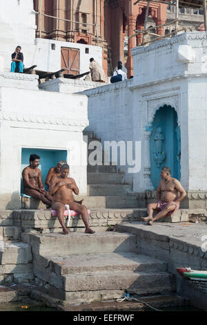 Varanasi, Indien. Hindu Männer Sonnenbaden auf den Ghats nach Ritual Baden im Ganges-Fluss Stockfoto