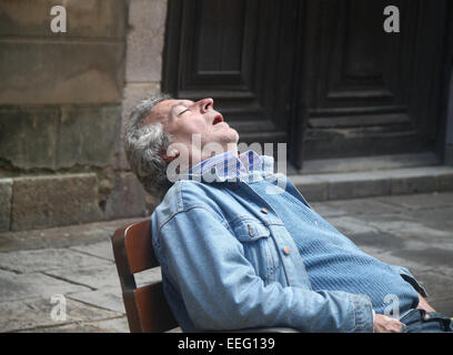 Im mittleren Alter Mann auf Sitz außerhalb im alten Hof in Barcelona, Spanien Stockfoto