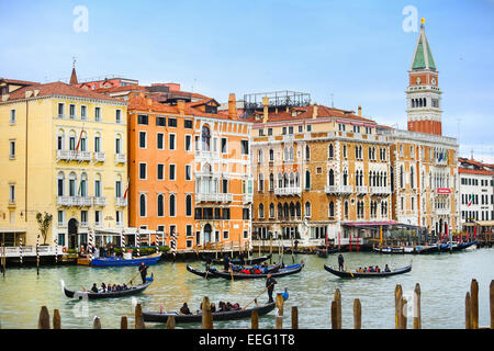 Gondeln mit Touristen segeln durch den Canal Grande mit Blick auf die St Mark Glockenturm Campanile in Venedig, Italien. Stockfoto