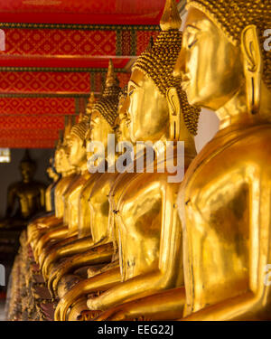 Reihe von goldenen Buddhas im Wat Pho, Bangkok. Stockfoto