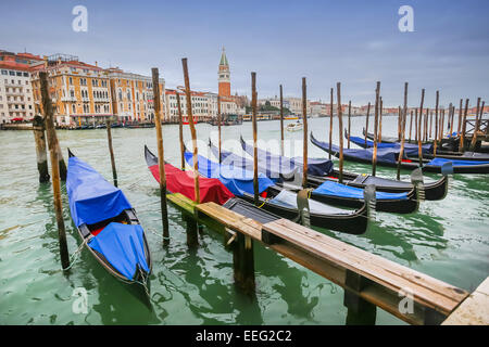 Einen Blick auf leere Gondeln festgemacht und aufgereiht an einem Gondel Dock in einem Wasserkanal in Venedig, Italien. Stockfoto