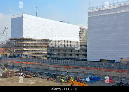 Sozialer Wohnungsbau Immobilien gehüllt in Plastikplanen & Gerüste für Sicherheit während der Abbrucharbeiten mit neuen Baumaßnahmen auf geräumten Bereich UK gestartet Stockfoto