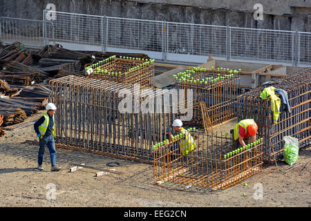 Gelbe Safety Caps auf Stahl Bars & Eisenflechter prefabricating Käfigen der Bewehrung für die Platzierung per Kran in Stiftungen UK Stockfoto