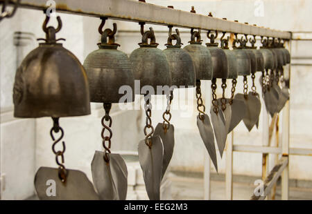 Eine Reihe von Bronzeglocken im Tempel des goldenen Buddha in Bangkok, Thailand. Stockfoto