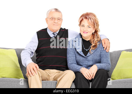 Schönes älteres paar posiert sitzend auf Sofa auf weißen Hintergrund isoliert Stockfoto