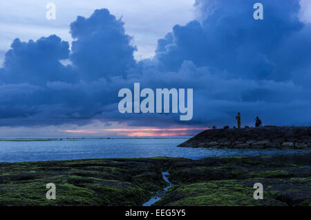 Fischer inne, um den Sonnenuntergang am Sunabe Beach in Okinawa, Japan. Stockfoto