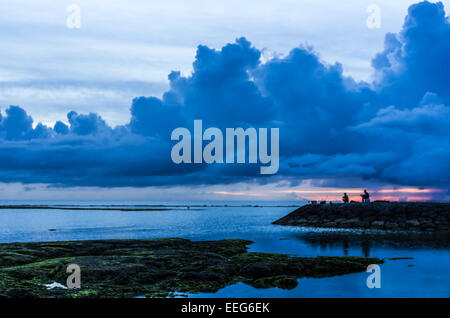 Fischer inne, um den Sonnenuntergang am Sunabe Beach in Okinawa, Japan. Stockfoto