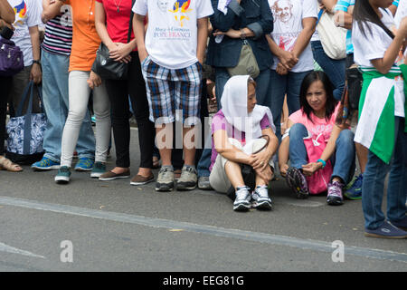 Intramuros, Manila, Philippinen, 16. Januar 2015. Filipinos aus allen Bereichen des Lebens zu sammeln und die Wagenkolonne der Papst Francis auf Freitag, 16. Januar 2015 einen Blick des Heiligen Vaters während seiner Apostolischen Reise auf die Philippinen zu warten. Stockfoto