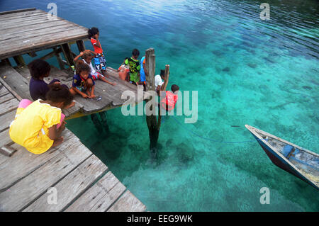 Kinder Fischerei vor der Anlegestelle in Yenbeser Dorf, Gam Insel, Raja Ampat, Provinz Papua, Indonesien. Weder Herr PR Stockfoto