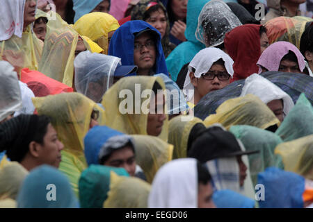 Manila, Philippinen. 18. Januar 2015. Menschen tragen Regenmäntel bei Regen gebracht tropischer Sturm Mekkhala während einer Messe in Manila, Philippinen, 18. Januar 2015. Mindestens 2.000 Familien wurden evakuiert in sechs Provinzen in Zentral-Philippinen als tropischer Sturm Mekkhala, lokal bekannt als Amang, zerschlagen das Land, die Staat Disaster Management Agency, sagte am Sonntag. Bildnachweis: Rouelle Umali/Xinhua/Alamy Live-Nachrichten Stockfoto