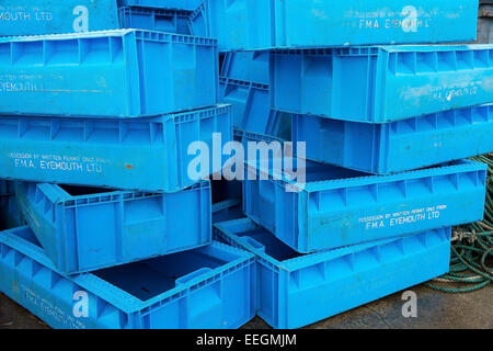 Blaue Kunststoff Fisch-Kisten stapeln sich am Hafen von einem Fischerdorf in Schottland. Stockfoto