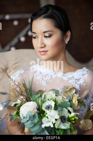 Ungewöhnliche Hochzeit Bouquet mit Ranunkeln, Freesien, Rosen und weißen Anemone im retro-Stil in Händen einer Braut Stockfoto