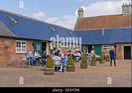 Das Café im Schloss Ashby Shopping Hof, Kunden bei Außengastronomie genießen die warme Sonnenstrahlen. Stockfoto
