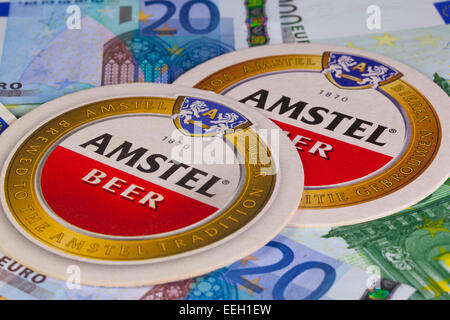 England, London - 11 November, 2014:Beermats von Amstel Bier und Eur Geld. Amstel-Brauerei ist eine niederländische Brauerei, gegründet im Jahre 1870 auf Stockfoto