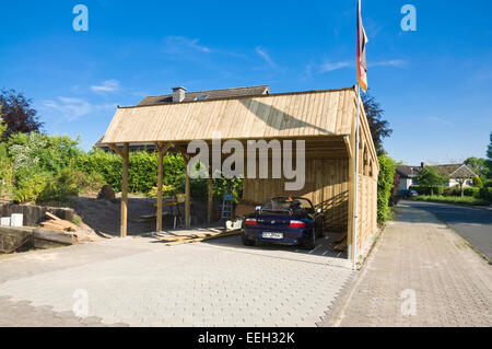 Solar-Carport "Sunport" Bereitstellung von Unterkünften und Ladeenergie für zwei EV-Elektroautos - hier mit einem konventionellen BMW Z3 Stockfoto