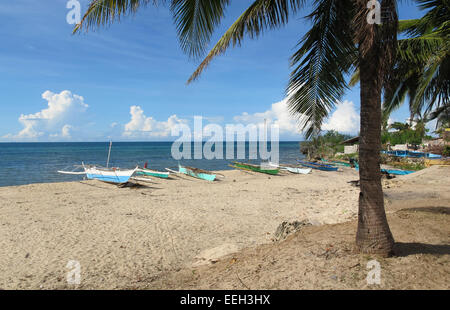Tropischer Strand mit Ausleger-Kanus und Palmen auf Bantayan Insel in den Philippinen Stockfoto