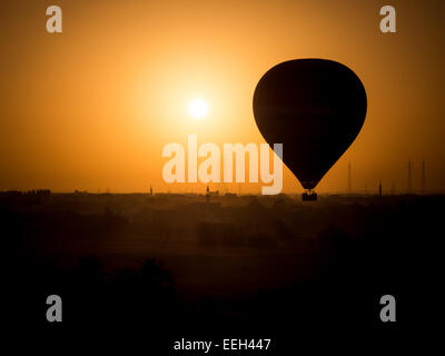 Silhouette von einem touristischen Heißluftballon über Luxor, Ägypten bei Sonnenuntergang Stockfoto