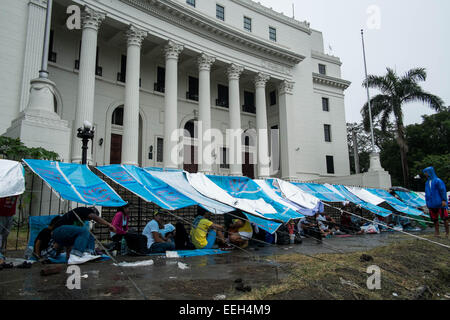 Manila, Philippinen. 18. Januar 2015. Römisch-katholische Gläubige verwenden Säcke, um Schutz vor dem Regen zu machen, während des Wartens auf die päpstliche Masse. Bildnachweis: Mark Z. Saludes/Pacific Presse/Alamy Live-Nachrichten Stockfoto