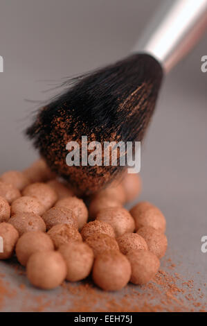 Nahaufnahme von kosmetischen bronzing Puder / Stiftung Perlen und Kosmetik Pinsel. Stockfoto