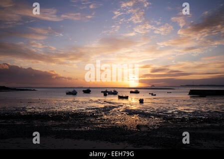 Boote bei Sonnenaufgang im Hafen von Lindisfarne, Holy Island, Northumberland, England. Silhouette Stockfoto