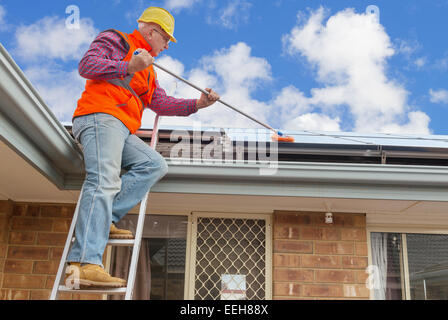 erfahrene Arbeiter Reinigung Solarzellen auf Hausdach Stockfoto
