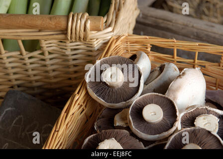 Frische Pilze und Gemüse zum Verkauf in Weidenkörbe in einem ländlichen Bauernhof shop Stockfoto