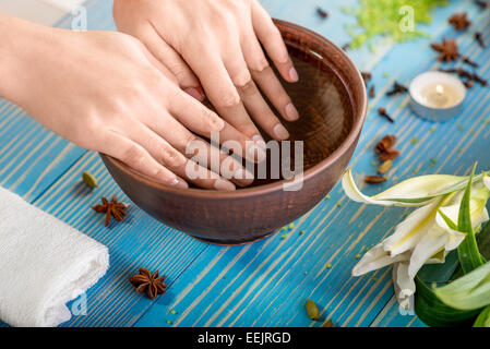 Einweichen Finger Nägel in die Wanne mit Wasser auf Holztisch mit Spa Zeug auf Hintergrund Stockfoto